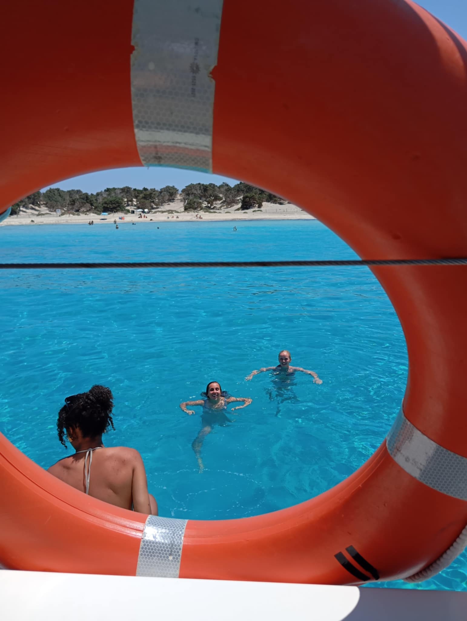 Swimmers seen through a life ring — guests enjoying the water